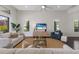 Bright and airy living room features modern furniture, plantation shutters, and backyard views at 16734 Collingtree Xing, Lakewood Ranch, FL 34202