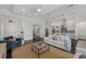 Open-concept living room flows into the kitchen, featuring modern decor, and dark wood floors at 16734 Collingtree Xing, Lakewood Ranch, FL 34202