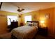 Comfortable bedroom with a ceiling fan, carpet, and a beautifully decorated bed and matching side tables at 1815 Restful Dr # N-27, Bradenton, FL 34207