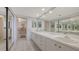 Bright bathroom features double sinks with a large mirror and white cabinets at 2020 Harbourside Dr # 454, Longboat Key, FL 34228
