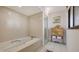 Relaxing bathroom features a soaking tub, separate glass shower, and a decorative cabinet with towels at 2020 Harbourside Dr # 454, Longboat Key, FL 34228
