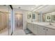 Bathroom with a double sink vanity, large mirror, and a walk-in shower at 2020 Harbourside Dr # 454, Longboat Key, FL 34228