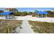 Beach club with covered picnic areas and a sandy path leading to the beachfront at 2020 Harbourside Dr # 454, Longboat Key, FL 34228