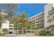 Multi-story condominium building showcasing multiple balconies, covered parking and tropical landscaping at 2020 Harbourside Dr # 454, Longboat Key, FL 34228