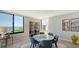 Bright dining area with stunning water views from large windows, features a round marble table and modern decor at 2020 Harbourside Dr # 454, Longboat Key, FL 34228