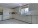 All-white kitchen featuring a large sink, tile floors, modern appliances, and bright natural light at 2020 Harbourside Dr # 454, Longboat Key, FL 34228