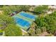 Aerial shot showcasing well-maintained tennis courts nestled among lush greenery and mature trees at 2020 Harbourside Dr # 454, Longboat Key, FL 34228