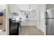 Clean kitchen features white cabinetry, black appliances, tiled floor, and a ceiling fan at 206 Elliot Ave # 137, Sarasota, FL 34232