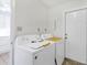 Functional laundry room with a washer and dryer, a door, and bright white walls at 206 Elliot Ave # 137, Sarasota, FL 34232