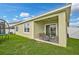 View of covered patio with outdoor seating overlooking the grassy backyard and white fence at 2417 Sand Gables Trl, Bradenton, FL 34208