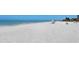 Expansive beach with white sand and gentle waves, perfect for relaxation under a colorful umbrella at 2675 Gulf Of Mexico Dr # 403, Longboat Key, FL 34228