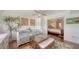 Bright bedroom featuring a daybed, tropical decor, and doorway to a Primary suite at 2675 Gulf Of Mexico Dr # 403, Longboat Key, FL 34228