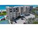 Exterior view of a stylish condo building, pool, tennis court, landscaped grounds, and close beach access at 2675 Gulf Of Mexico Dr # 403, Longboat Key, FL 34228