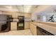 Well-lit kitchen features stainless steel appliances and beige cabinets with granite countertops at 2675 Gulf Of Mexico Dr # 403, Longboat Key, FL 34228