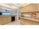Bright kitchen with granite countertops and beige cabinets offers views of the beach at 2675 Gulf Of Mexico Dr # 403, Longboat Key, FL 34228