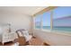 A cozy sitting area near a window with a wicker chair and an ocean view at 2675 Gulf Of Mexico Dr # 403, Longboat Key, FL 34228
