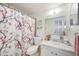 Bright bathroom with a shower-tub combo and a pink floral shower curtain at 270 E Langsner St, Englewood, FL 34223