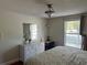 Bright bedroom featuring hardwood floors, a white dresser, large window, and natural light at 2816 N Lockwood Meadows Blvd, Sarasota, FL 34234