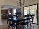 Dining room featuring a dark wood table, chandelier, view into kitchen, and sliding glass doors to sunroom at 2816 N Lockwood Meadows Blvd, Sarasota, FL 34234