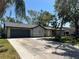 Charming single-story home with a two-car garage and a wide driveway, shaded by palm trees at 2816 N Lockwood Meadows Blvd, Sarasota, FL 34234
