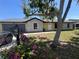 Charming single-story home with a two-car garage, stone accents, and a beautiful blooming tree at 2816 N Lockwood Meadows Blvd, Sarasota, FL 34234