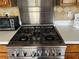 Close-up of a stainless steel gas range with white countertop and diamond-patterned backsplash in a well-equipped kitchen at 2816 N Lockwood Meadows Blvd, Sarasota, FL 34234