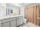 Clean bathroom featuring a vanity with double sinks, and a shower with curtain rod at 3027 Great Abaco Way, Bradenton, FL 34208