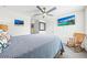 Comfortable bedroom with carpet flooring, ceiling fan, a mounted television, and a rocking chair at 3027 Great Abaco Way, Bradenton, FL 34208