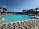 Large community pool with plenty of seating, surrounded by tropical palm trees and lush landscaping at 3027 Great Abaco Way, Bradenton, FL 34208