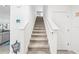Carpeted stairway featuring white railing and newel post, leading to the upper level of the home at 3027 Great Abaco Way, Bradenton, FL 34208