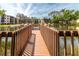 Long wooden dock stretches out onto the calm pond, surrounded by lush greenery at 305 30Th Ave W # A104, Bradenton, FL 34205