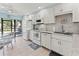 White kitchen featuring modern appliances and breakfast area with patio view at 305 30Th Ave W # A104, Bradenton, FL 34205