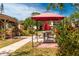 Outdoor picnic area featuring multiple tables with bright flowers and lush landscaping at 305 30Th Ave W # A104, Bradenton, FL 34205