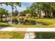 Scenic view of a pond with a fountain, gazebo, and lush green surroundings at 305 30Th Ave W # A104, Bradenton, FL 34205