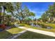 Picturesque view of a pond with a walking path and lush greenery under a sunny sky at 305 30Th Ave W # A104, Bradenton, FL 34205