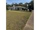 Wide view of home with white exterior, mature trees, and long driveway on expansive lawn at 3052 51St St, Sarasota, FL 34234