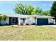 Charming single-story home with a well-maintained lawn and a dark-blue two-car garage at 3320 Riviera Dr, Sarasota, FL 34232