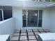 Cozy patio area with stone tiling and a glimpse of the interior through a large window at 3320 Riviera Dr, Sarasota, FL 34232