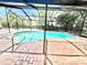 This screened pool features a brick patio and is surrounded by mature landscaping at 3320 Riviera Dr, Sarasota, FL 34232