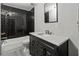 Modern bathroom features a new vanity, large wall mirror, and a shower and bathtub with black tiling at 3333 Ramblewood Pl, Sarasota, FL 34237