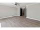 A spacious bedroom with gray vinyl plank flooring and modern ceiling fan and access to additional rooms at 3333 Ramblewood Pl, Sarasota, FL 34237