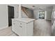 Open-concept view of kitchen island with white cabinets and modern finishes flowing into the living room at 3333 Ramblewood Pl, Sarasota, FL 34237
