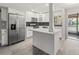 Modern kitchen featuring white cabinets, stainless steel appliances, and a stylish black backsplash at 3333 Ramblewood Pl, Sarasota, FL 34237