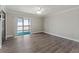 Open living room with wood flooring and a sliding glass door to an enclosed balcony at 3333 Ramblewood Pl, Sarasota, FL 34237