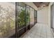 Screened patio with tile flooring featuring an outdoor area with lush greenery at 3333 Ramblewood Pl, Sarasota, FL 34237
