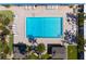 Aerial view of a rectangular community pool with lounge chairs, lush landscaping, and nearby cabana structures at 3802 Gulf Of Mexico Dr # A103, Longboat Key, FL 34228