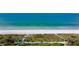 Aerial beach view showcasing white sand, turquoise water, lush dunes, and a palm-lined walking path at 3802 Gulf Of Mexico Dr # A103, Longboat Key, FL 34228