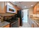 A kitchen featuring light wood cabinets, granite countertops, and a black appliance package at 3802 Gulf Of Mexico Dr # A103, Longboat Key, FL 34228