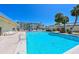 Community outdoor swimming pool surrounded by lounge chairs and tropical landscaping with residential buildings in the background at 3802 Gulf Of Mexico Dr # A103, Longboat Key, FL 34228