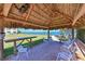 Tiki hut seating area with a thatched roof, chairs, and scenic views of the ocean and nearby dock at 3802 Gulf Of Mexico Dr # A103, Longboat Key, FL 34228